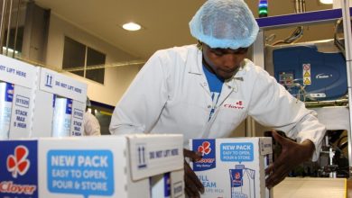 A man in a white lab coat working on a box.