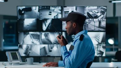 A man in a blue shirt attentively gazes at a monitor displaying information. Security Officers X143.
