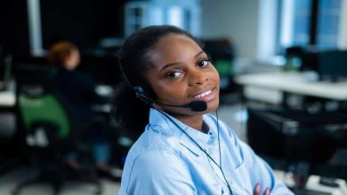 A woman using a headset in an office, illustrating SANRAL's recruitment for 38 Permanent Contact Centre Agent positions.