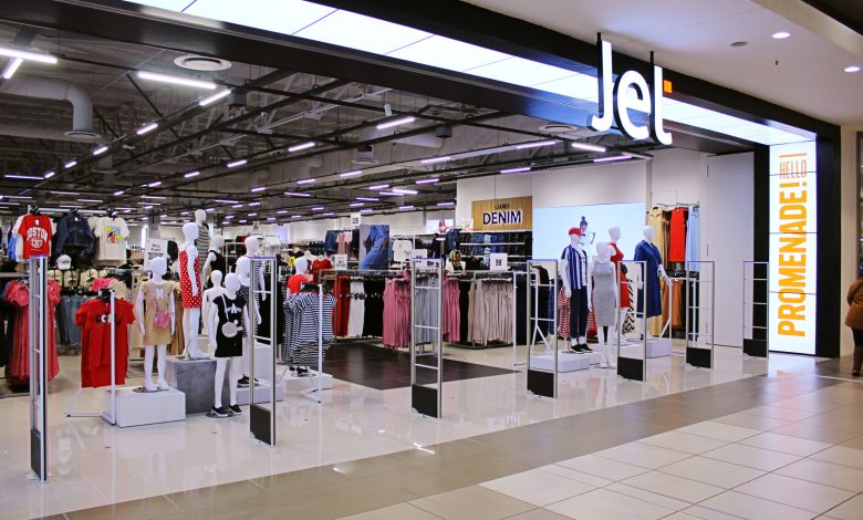 A vibrant store filled with clothing displays, advertising festive job openings at JET Retail Stores for the holiday season.