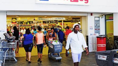 A man strides past a Pick n Pay store, highlighting learnership opportunities in wholesale and retail for 2026.