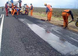 Road workers laying asphalt, emphasizing available job opportunities for road workers.