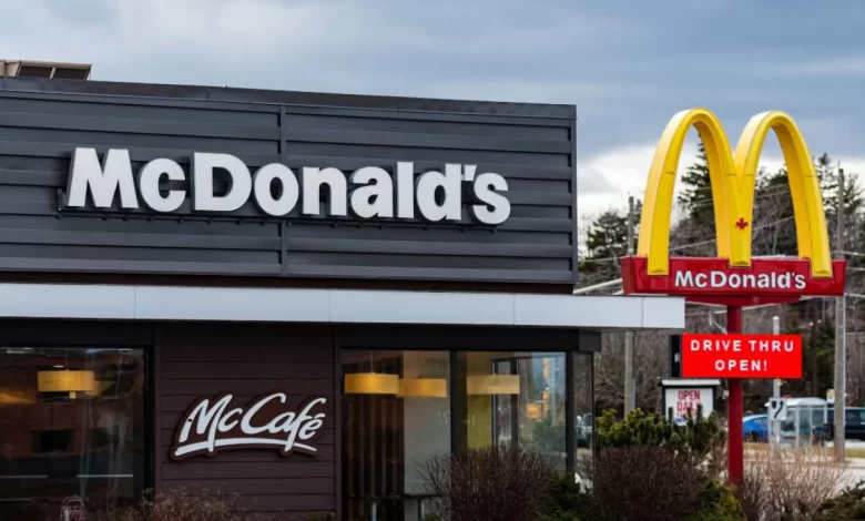A woman in a blue uniform is positioned at a McDonald's kiosk, advertising job openings for 2025.